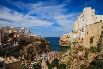 Beautiful view of Polignano a Mare with a lot of tourists sunbathing on the beach, Bari Province,...