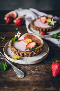 From above portions of delicious strawberry and citrus cakes served on decorated wooden table