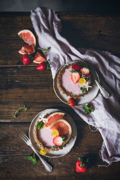 From above portions of delicious strawberry and citrus cakes served on decorated wooden table