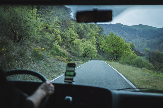 View from inside car of empty road of rural area in overcast weather