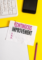 Text sign showing Continuous Improvement. Business photo text ongoing effort to improve products or processes Crumpled white paper on table with paper clips clock mobile and pc keyboard