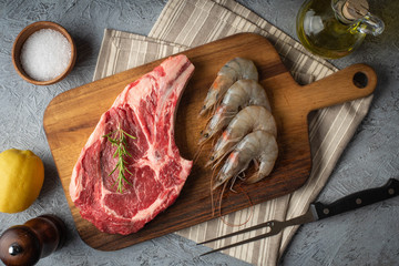 raw ribeye steak and prawn, surf and turf preparation