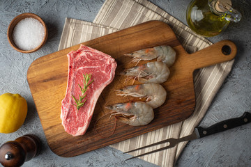 raw new york strip steak and prawn, surf and turf preparation