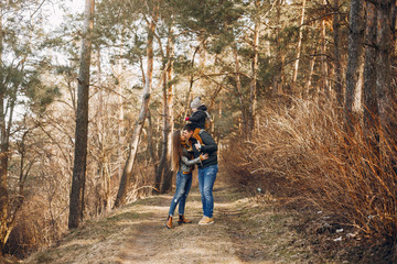 Obraz premium Family with cute little son. Mother in a yellow sweater. Parents with child in a spring park