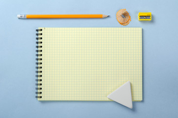 Yellow notebook, pencil sharpener, pencil and eraser. Top view with copy space.