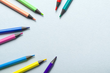 Colored pencils scattered on the desktop. Top view with copy space.