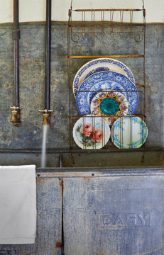 Decorative plates on rack next to taps
