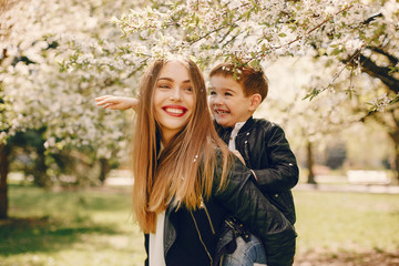 Family in a summer park. Mother in a black jacket. Cute little boy