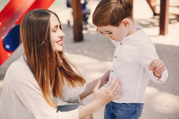 Family in a summer park. Mother in a white shirt. Cute little boy