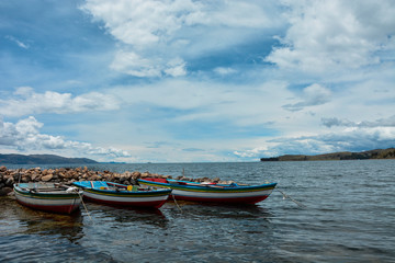 lanchas coloridas de madera en lago y de fondo nubes