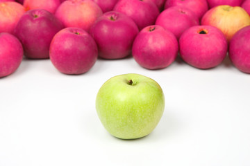 Green Apple on a background of red apples on white background