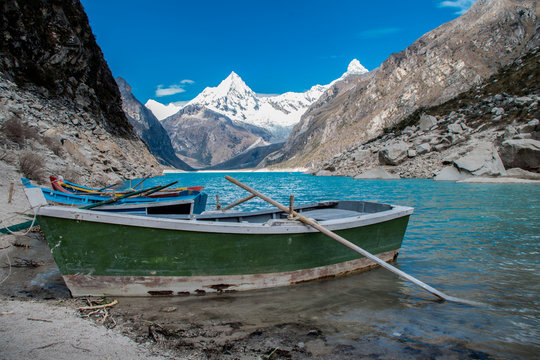 Old boat in the coast of the beautiful Lake Paron. Behind you can see the Piramide Mountain. Cordillera blanca of The Andes, Peru.