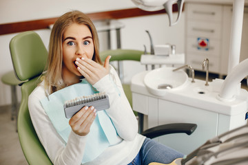 Beautiful lady in the dentist's office. Blonde sitting in a chair