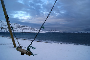Swings on a sea winter coast. fly to the sky. freedom icon