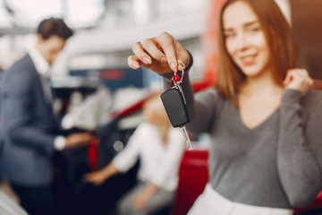 Woman buying the car. Lady in a car salon. Manager with a clients