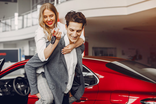 Couple buying the car. Pair in a car salon. Husband with vife choose the automobile