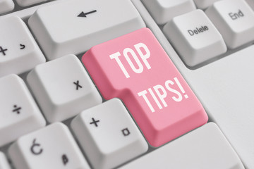 Conceptual hand writing showing Top Tips. Concept meaning small but particularly useful piece of practical advice White pc keyboard with note paper above the white background