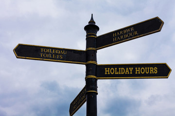 Fototapeta premium Word writing text Holiday Hours. Business photo showcasing employee receives twice their normal pay for all hours Road sign on the crossroads with blue cloudy sky in the background