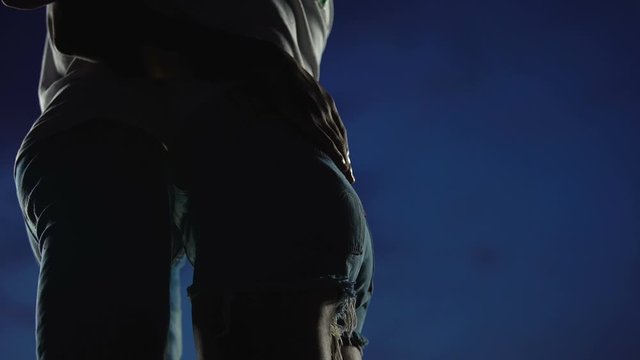 Slim girl embracing boyfriend to kiss against night sky, youth love story
