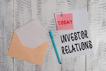 Writing note showing Investor Relations. Business concept for analysisagement responsibility that integrates finance Envelope blank sheet sticky note ballpoint wooden background