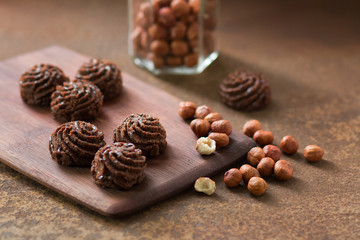 Truffle chocolate mini-cakes on a rusty metal surface, bank with a filbert. Sweets and nuts