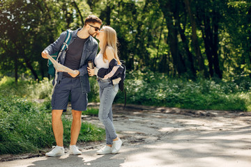 Tourists in a summer forest. Couple with a map.