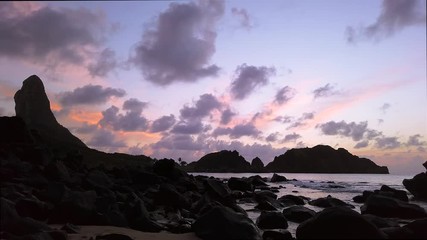 Fernando de Noronha Island, a UNESCO World Heritage site, Pernambuco, Brazil - July, 2019 - 4k footage of colorful sunset at Cachorro Beach with the beautiful view of the Pico Hill, Conceição Beach.