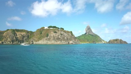Fernando de Noronha Island, a UNESCO World Heritage site, Pernambuco, Brazil - July, 2019 - 4k footage at Porto Santo Antonio beach with the view of Pico Hill and beautiful dolphins swimming
