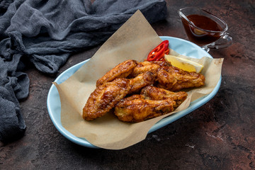 chicken wings in barbecue sauce on dark concrete rustic table
