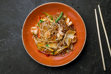 wok with shrimp and seafood on black concrete table