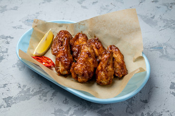 chicken wings in barbecue sauce on grey concrete table