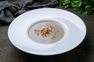 Cream soup of mushrooms on black concrete table