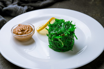 Chuka salad with peanut sauce on black concrete table