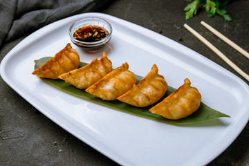 Fried Chinese gedza with soy sauce on black concrete table