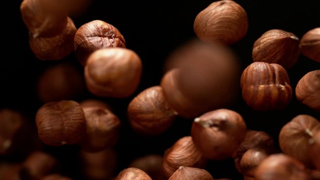 Super slow motion of flying hazelnuts on black background. Filmed on high speed cinema camera, 1000 fps.