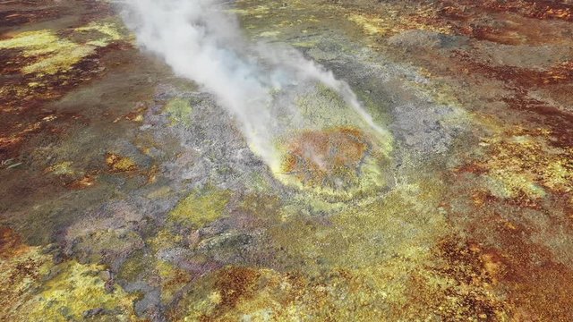 Tilting drone footage of spectacular smoking acid crater of Dallol volcano (hydrothermal field), surreal desert landscape in remote location Danakil depression in Ethiopia, Africa