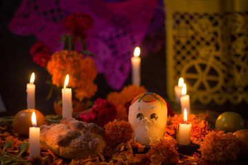 Altar del día de muertos en México con calavera de azúcar, flores y papel picado