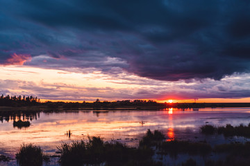Sunset with stormy clouds reflecting in lake