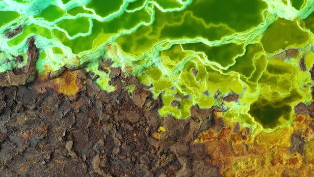 Overhead drone shot of crust of volcano filled with pools of minerals in Dallol, Ethiopia