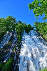青空バックに豪快なオシンコシンの滝の情景＠知床、北海道