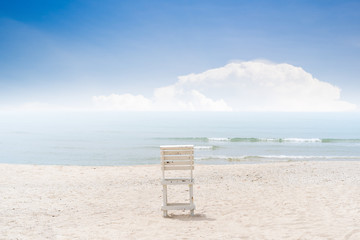 Vintage white wooden chair left on the beach.  The beautiful beach in Thailannd with beautiful blue sky and cloud background.