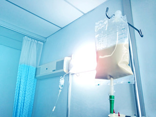 Fototapeta na wymiar Bluetone of Enteral feeding bag on IV pole in patian room.