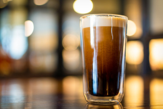 Beautiful texture and layers of Nitro Cold Coffee served in a dubble wall glass close up.
