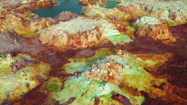 Ascending drone shot of volcanic sulfur fields of Dallol in the famous Danakil Depression, hot springs and acid mineral deposits in surreal landscape in Ethiopia, Africa