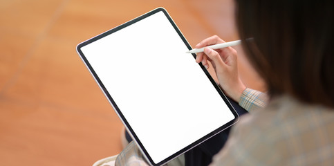 Young businesswoman writing on blank screen tablet