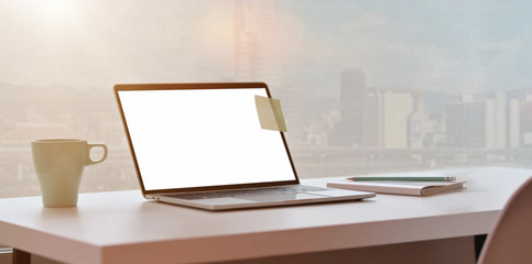 Modern workplace with laptop and city view background