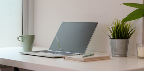 Open blank screen laptop computer with coffee cup
