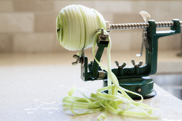 A transparent green apple being peeled and cored with an 