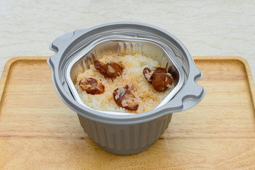 side view raw self cooking fast food of rice with sausage slices