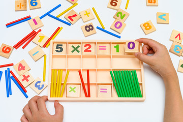 kid doing multiplication equation using counting rods